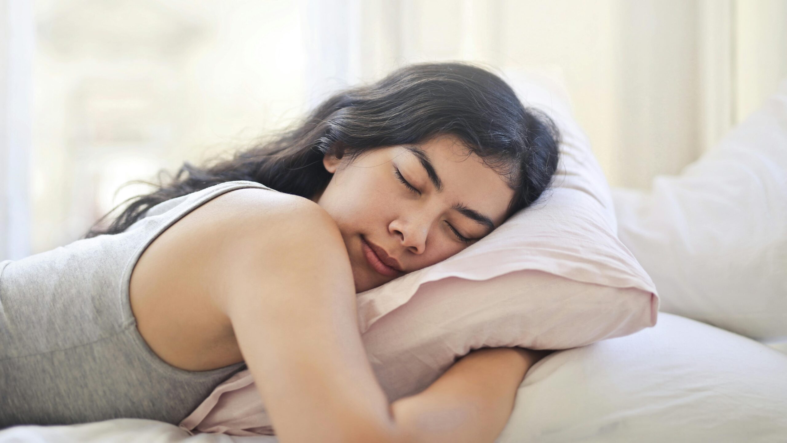 Woman in Gray Tank Top Lying on Bed